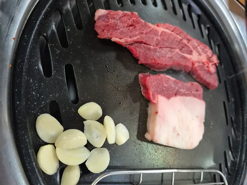 숯불 위에 올려진 말고기와 마늘