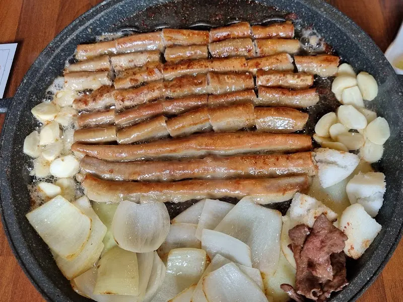 불판 가득 채운 곱창, 양파, 마늘