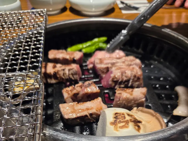 잘 익은 고기를 집게로 들어올리는 모습