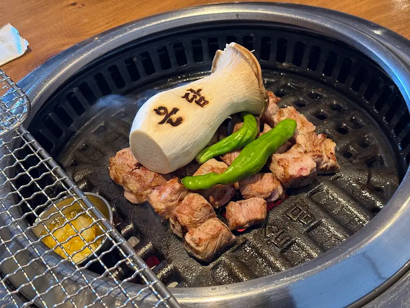 불판 위에서 맛있게 익어가는 고기와 버섯, 고추