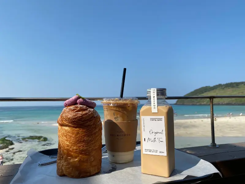 함덕 바다를 배경으로 놓인 라떼와 크로와상