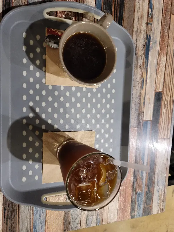 쟁반 위에 놓인 머그컵에 담긴 따뜻한 아메리카노와 아이스 아메리카노