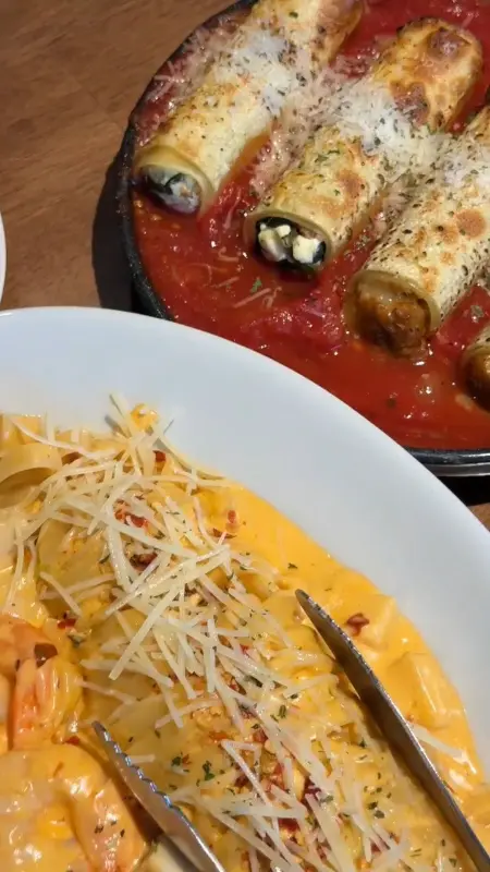 돌돌 말린 롤 형태의 라자냐 위에 토마토 소스와 크림치즈가 듬뿍 올려진 모습