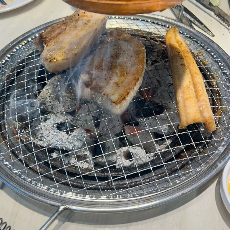 숯불 위에서 지글거리는 삼겹살과 장어