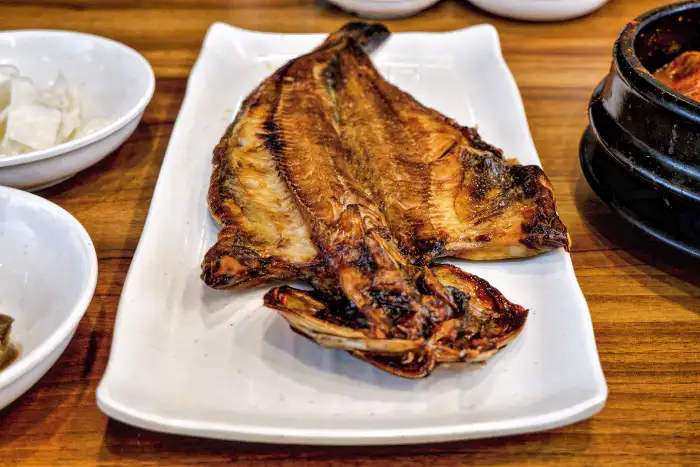 접시에 놓인 통으로 구워진 생선