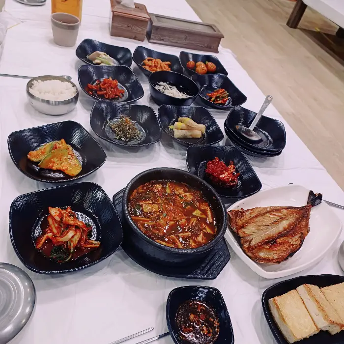 테이블에 차려진 한정식 상차림, 생선구이와 찌개 등