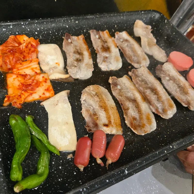 불판 위의 삼겹살과 김치