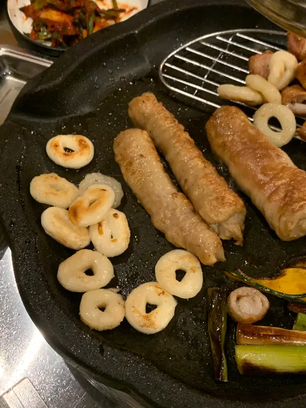 잘 구워진 막창과 꽈리고추, 마늘이 불판 위에 놓여있다. 노릇노릇한 막창의 색깔이 식욕을 자극한다.