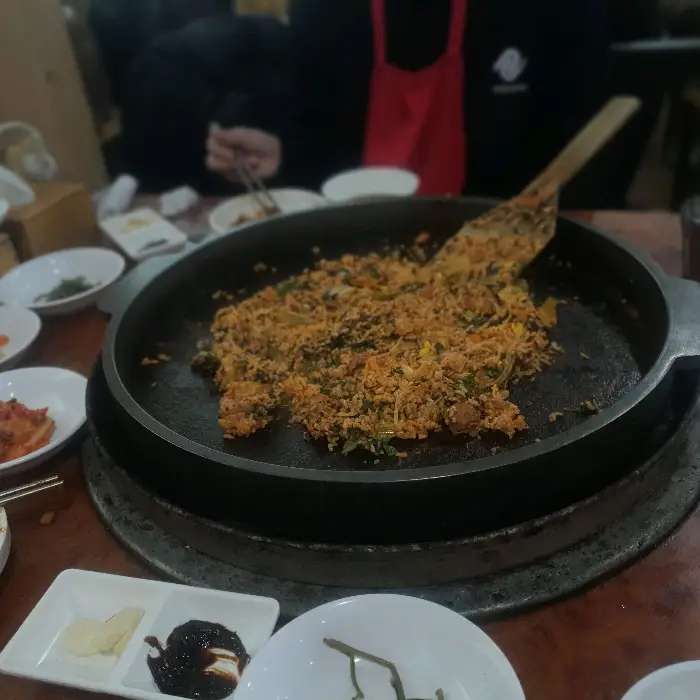 철판에 볶음밥이 만들어지고 있는 모습. 밥알과 양념이 잘 섞여 있습니다.