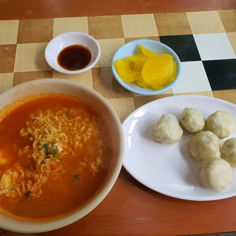 테이블 위에 놓여진 라면과 단무지