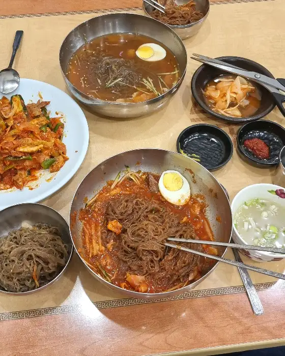 비빔밀면과 물밀면, 수육무침 등이 함께 나온 테이블 사진