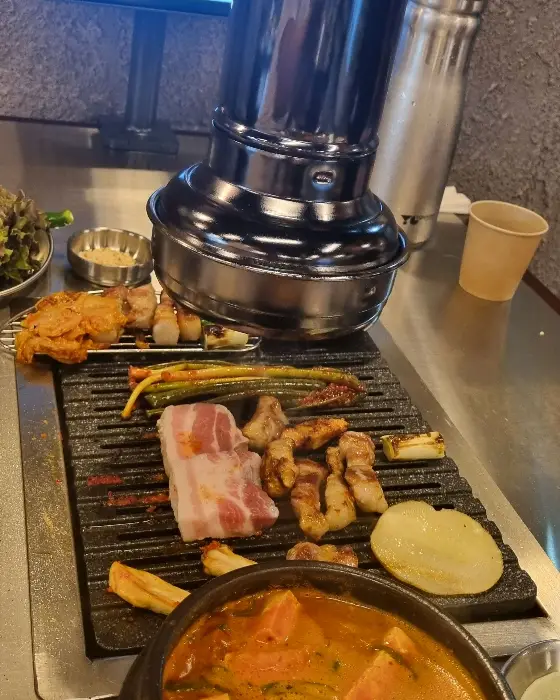 숯불 위에서 구워지는 고기와 찌개