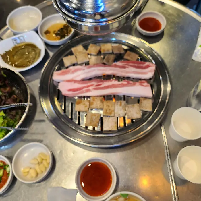 잘 익은 삼겹살 조각과 곁들임 찬