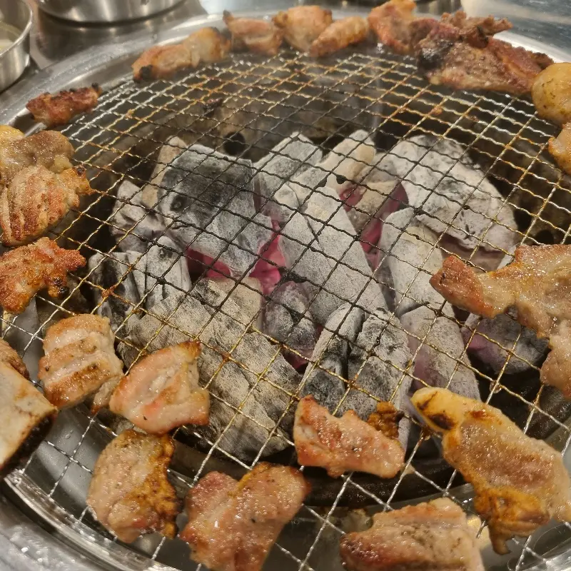 숯불 위에서 노릇하게 익어가는 고기