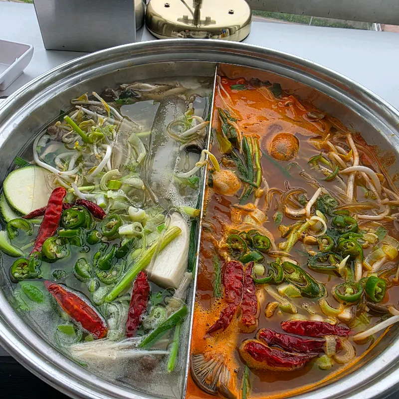 멸치 육수와 얼큰마늘 육수가 반반씩 담긴 냄비의 모습