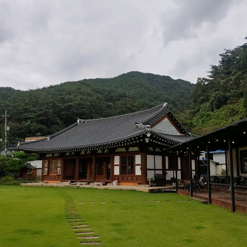 한옥 건물과 푸른 잔디밭이 어우러진 카페 소나무의 아름다운 모습