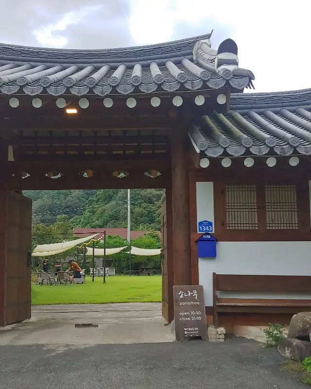 한옥 카페 소나무의 정문. 고풍스러운 기와지붕과 나무 문이 인상적이다.