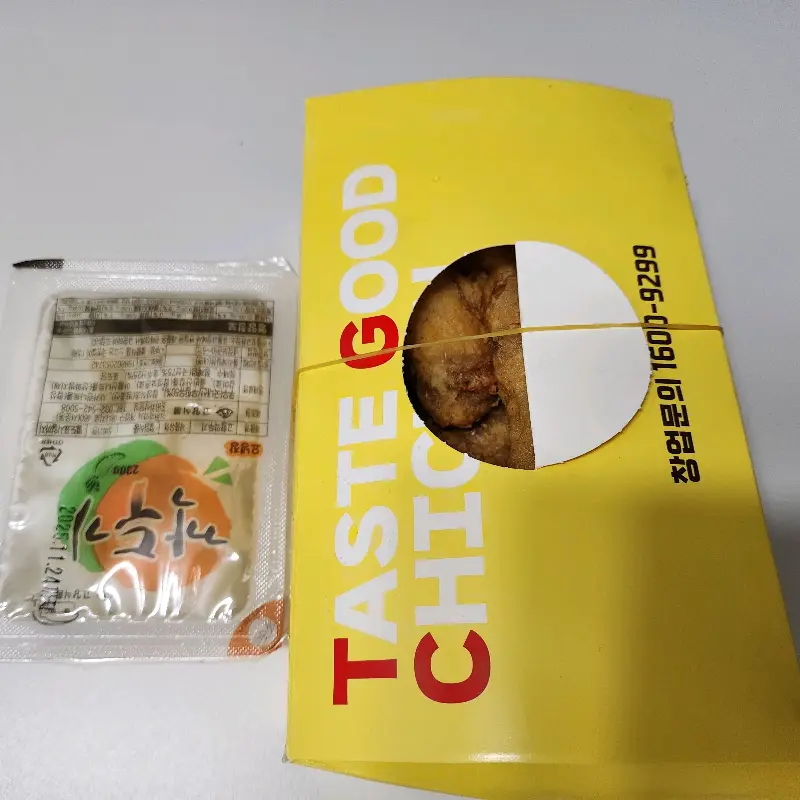 깔끔하게 포장된 치킨과 소스