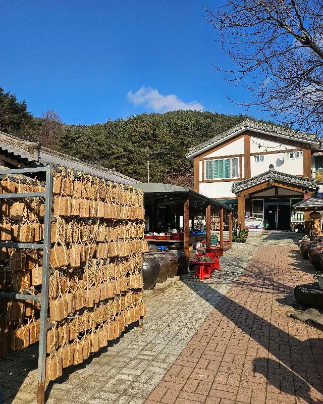 식당 외부 전경, 옹기들이 줄지어 서 있는 모습이 인상적이다.