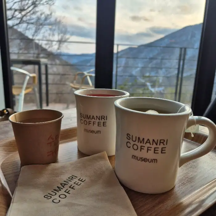 창밖 풍경을 배경으로 놓인 커피 잔