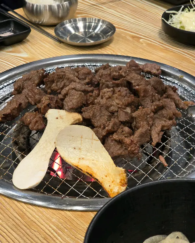 불판 위에서 익어가는 갈비살과 버섯