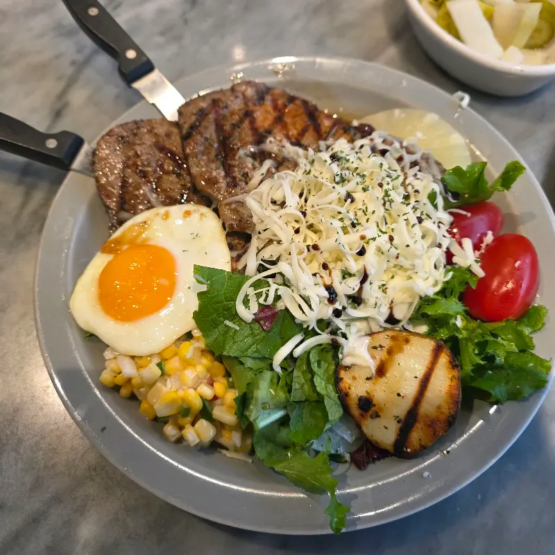 스테이크와 샐러드가 함께 담겨 있는 모습