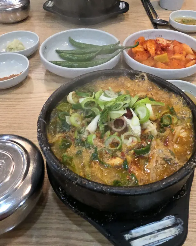 해장국, 깍두기, 고추가 함께 놓인 테이블