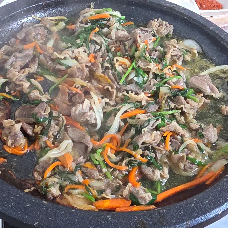 불판 위에서 맛있게 익어가는 오리불고기