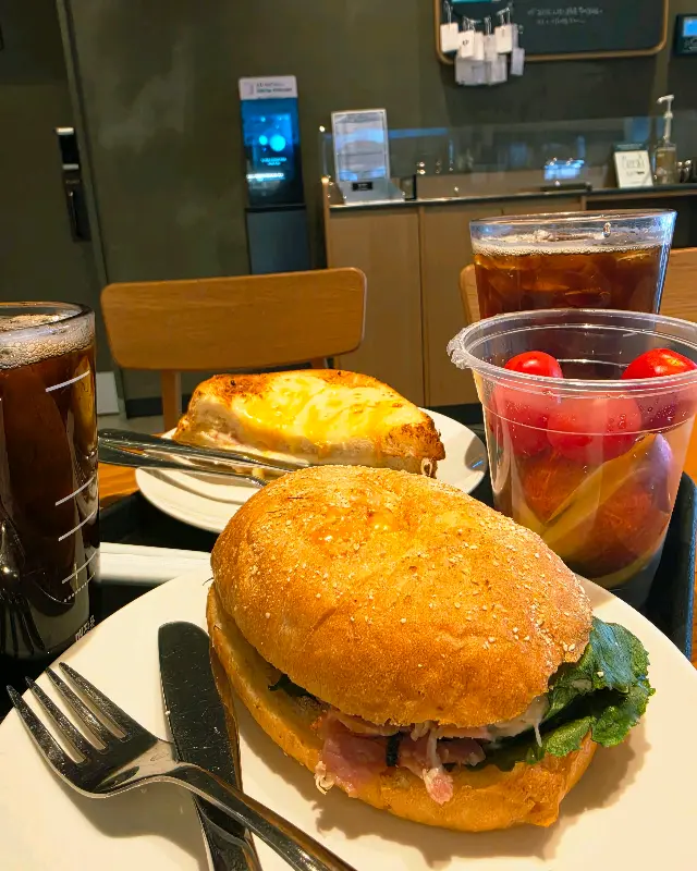 샌드위치, 크로크무슈, 과일컵, 아이스 아메리카노가 놓인 테이블