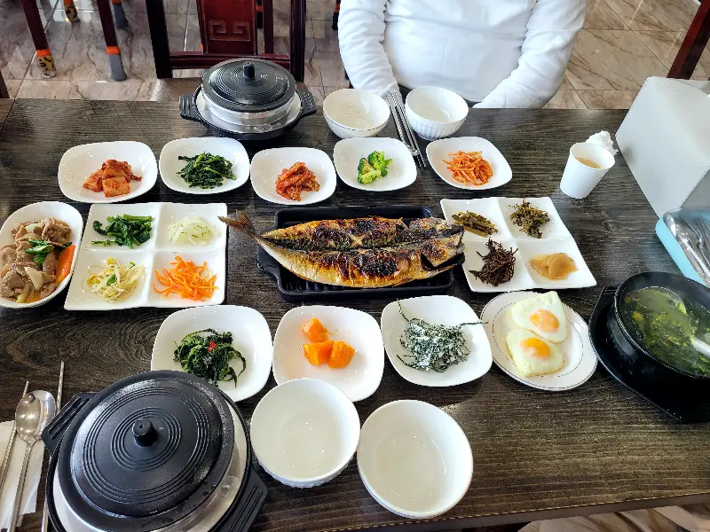 고등어구이와 다양한 반찬, 솥밥, 미역국이 함께 차려진 푸짐한 한 상