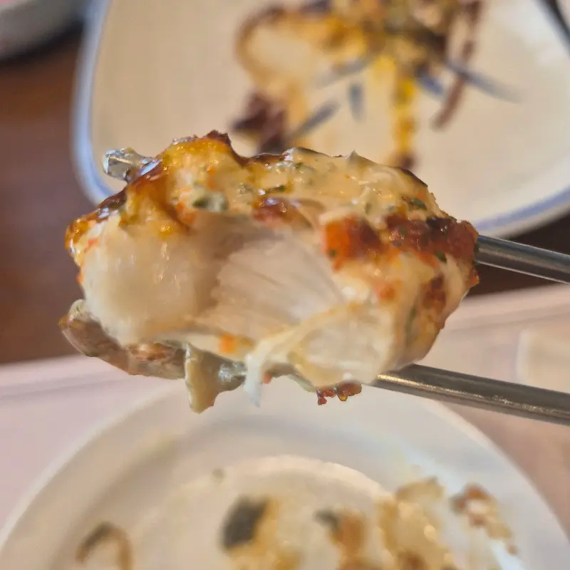 젓가락으로 집어 올린 생선 요리