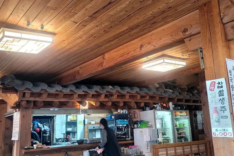 한옥 지붕 아래 은은하게 빛나는 조명이 따뜻한 분위기를 자아내는 토방의 내부