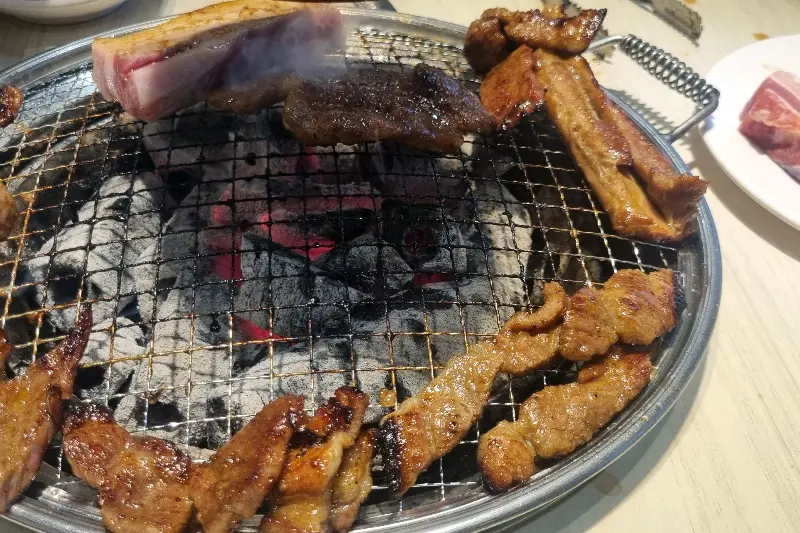 숯불 위에서 익어가는 갈비와 삼겹살