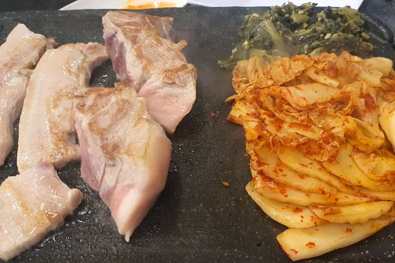 불판 위의 삼겹살과 김치