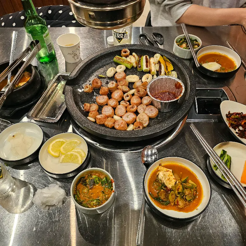 테이블 위에 놓인 컵에 맥주가 담겨 있다. 시원한 맥주와 함께 막창을 즐기는 모습이 담겨 있다.
