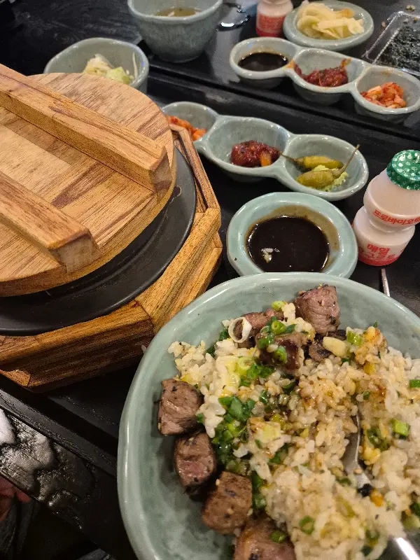 스테이크 솥밥을 덜어 먹는 모습, 밥알 하나하나에 스테이크의 풍미가 배어 있다.