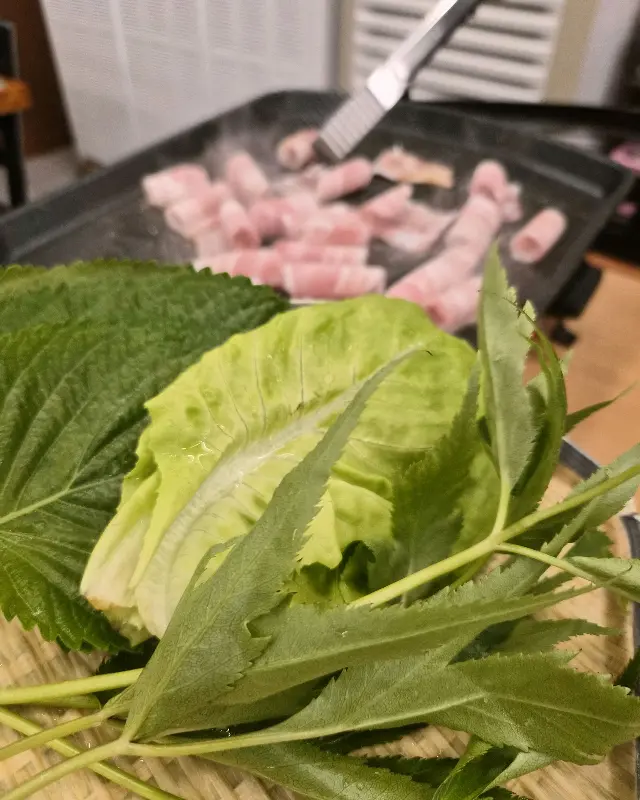 노릇하게 구워진 듀록 대패삼겹살과 신선한 쌈 채소