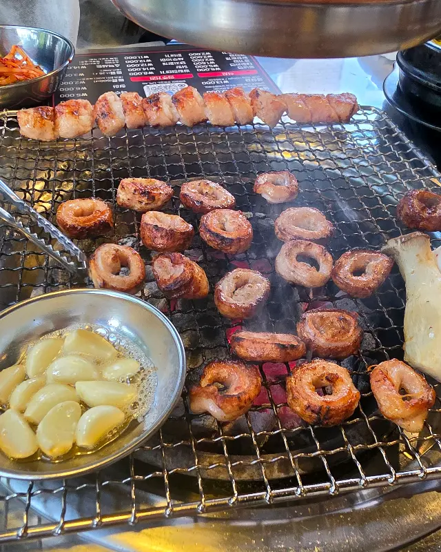 불판 위에서 익어가는 막창과 마늘, 버섯