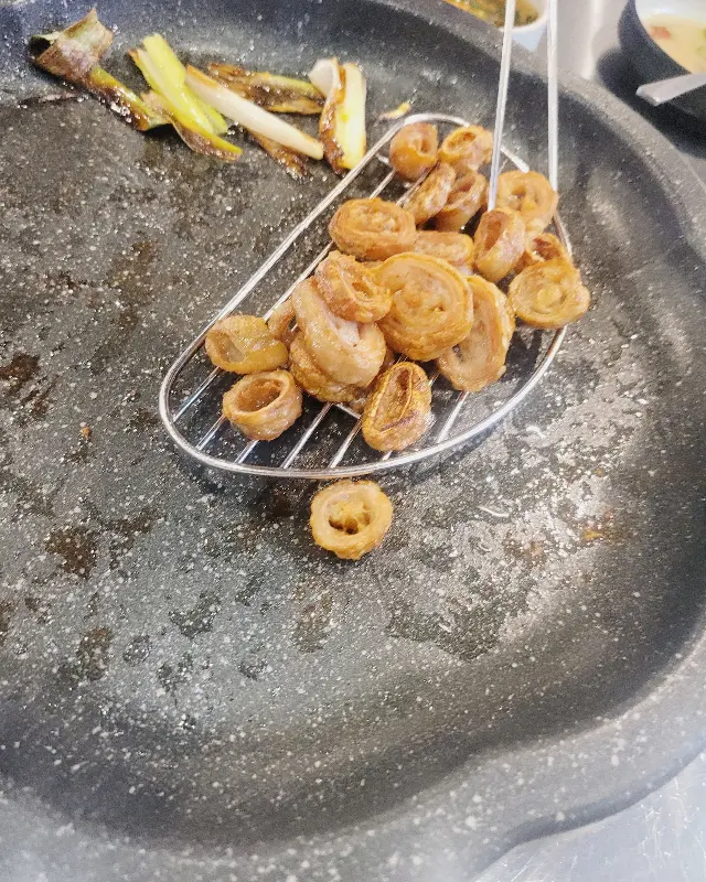 테이블 위에 놓인 메뉴판이 보인다. 연막창, 특막창, 차돌박이관자삼합 등 다양한 메뉴들이 적혀 있다.