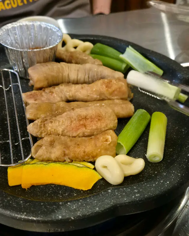 초벌된 막창이 불판 위에 올려지기 전 접시에 담겨 나온 모습이다. 꽈리고추와 마늘, 호박 등도 함께 제공된다.