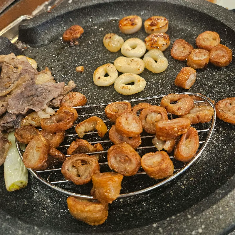 잘 구워진 막창들이 석쇠 위에 올려져 있다. 겉은 바삭하고 속은 촉촉해 보이는 막창의 모습이 인상적이다.