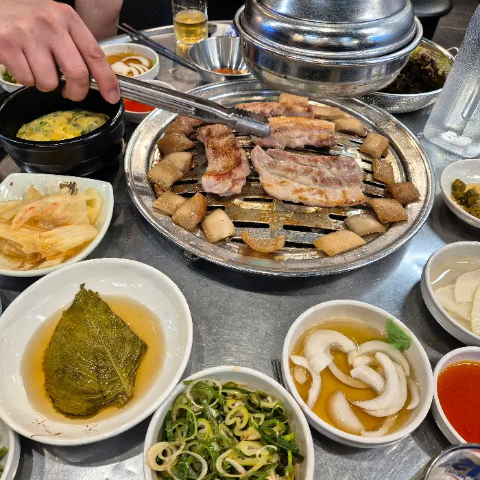 불판 위에서 맛있게 익어가는 삼겹살과 껍데기