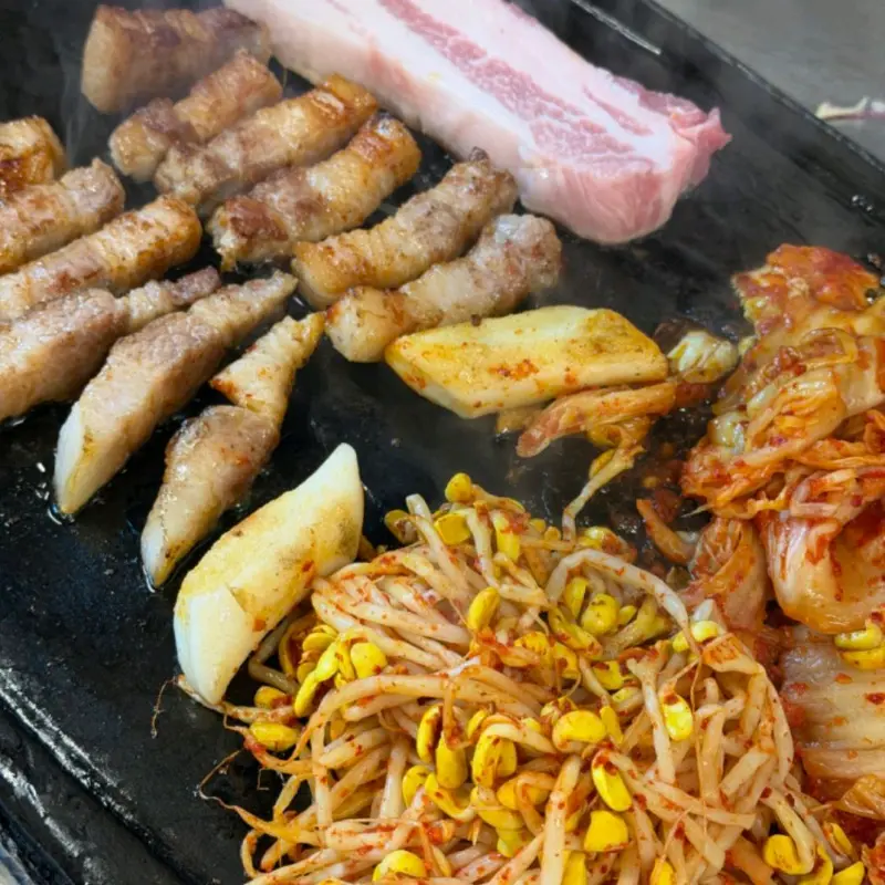 노릇하게 구워진 삼겹살과 김치, 콩나물의 환상적인 조합