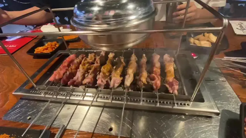 자동으로 돌아가는 꼬치 구이 기계 위에 가지런히 놓여 익어가는 양꼬치들