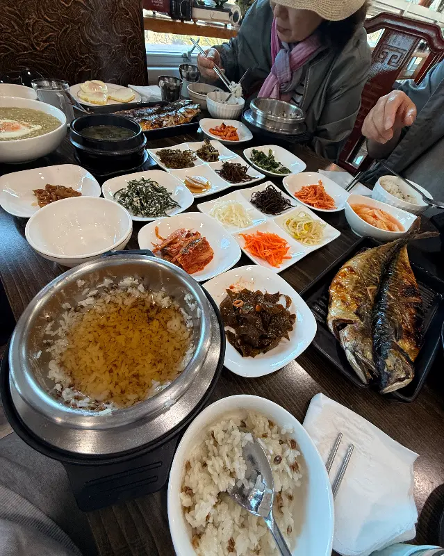 푸짐한 한 상 차림과 식사를 즐기는 사람들