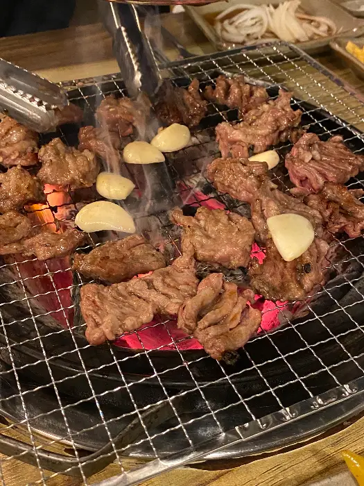 숯불 위에서 지글지글 익어가는 갈매기살과 마늘