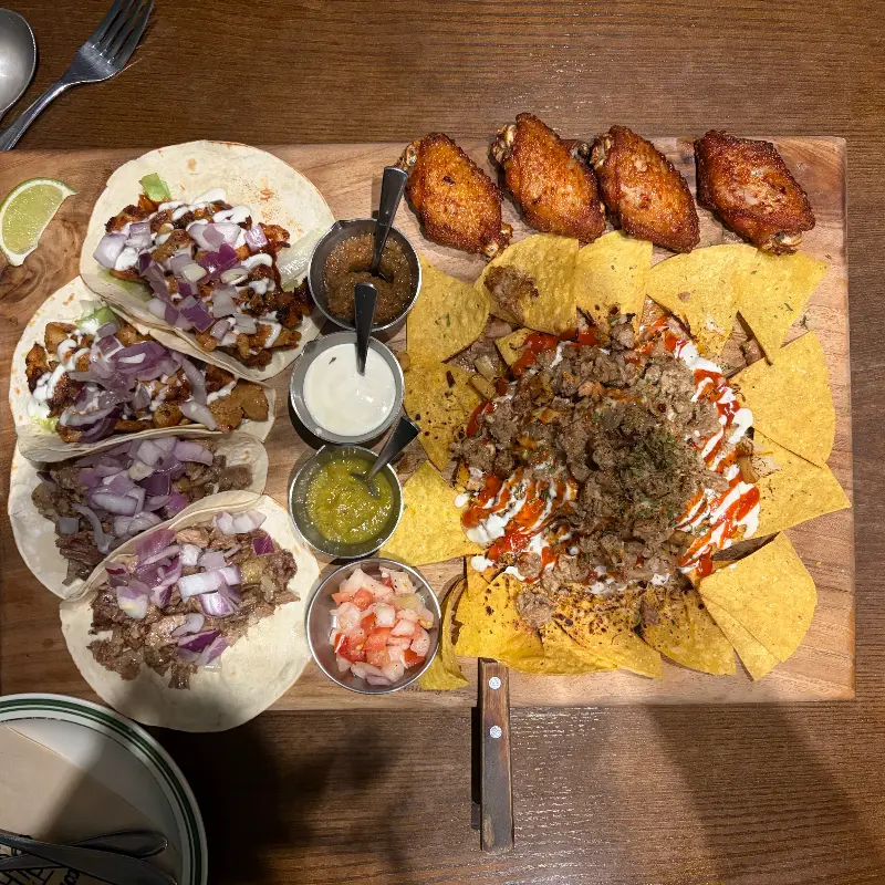 나무 도마 위에 푸짐하게 담긴 꼰미고 세트