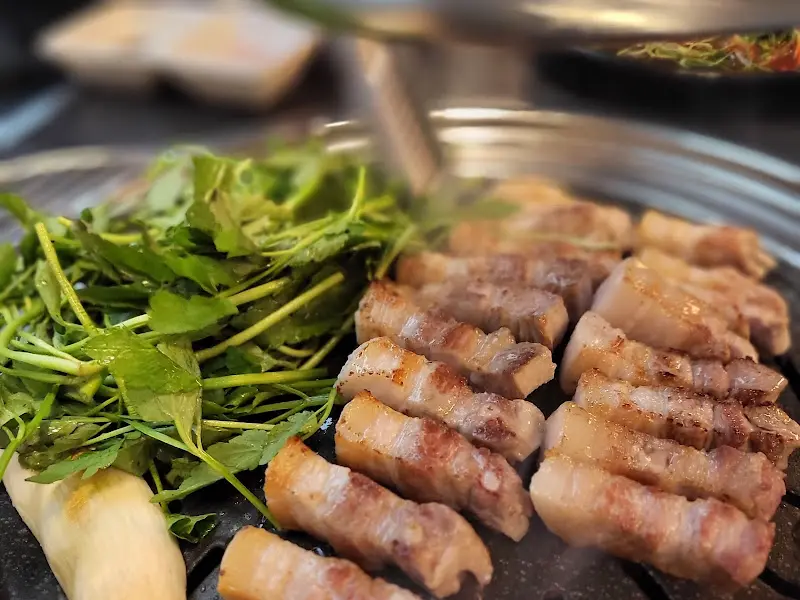 불판 위에 가지런히 놓인 삼겹살