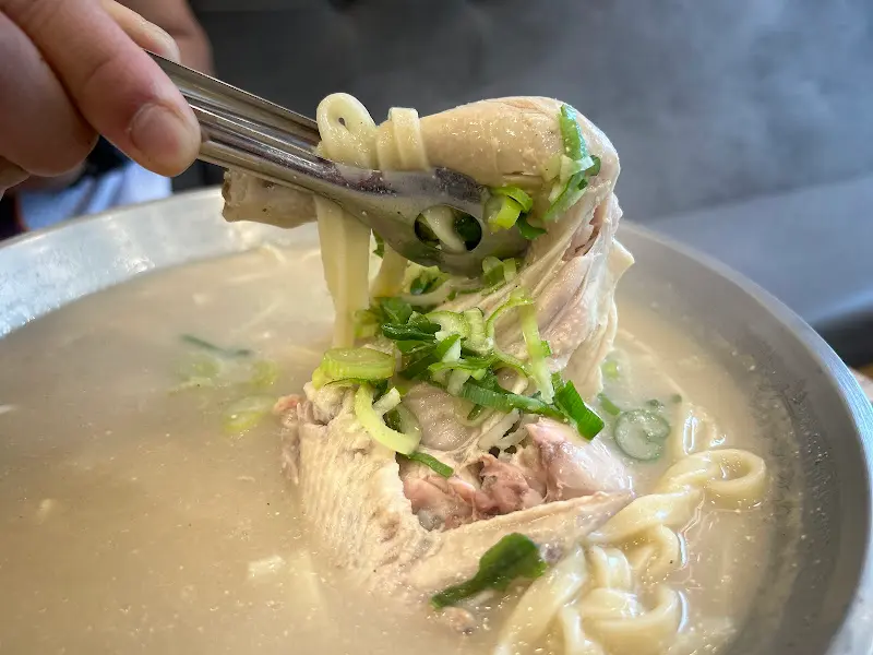 닭칼국수 속 닭고기를 젓가락으로 집어 올린 모습