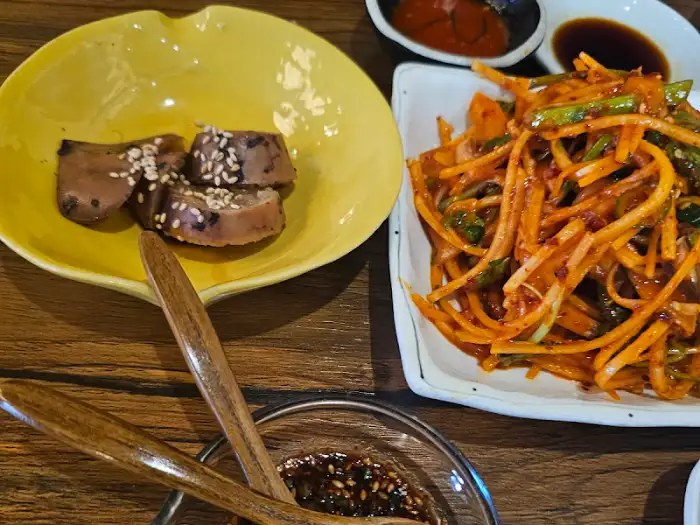 노란 접시에 담긴 잘게 썰린 음식과 양념장, 그리고 샐러드 같은 음식